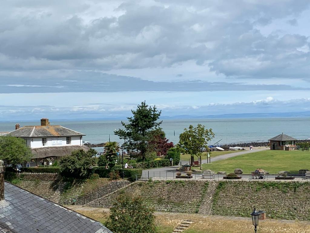 a view of a house with the ocean in the background at Postmans Rest, second floor apartment, Lynmouth with private parking in Lynmouth