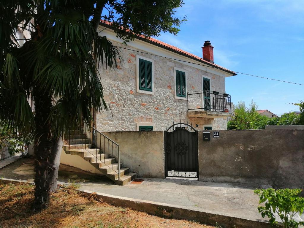 una casa vieja con una puerta y escaleras delante de ella en Studio apartman Adris en Šibenik