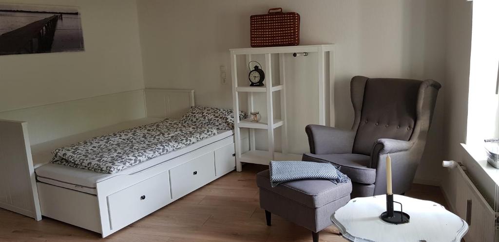 a small bedroom with a bed and a chair at Gästewohnung Wasserzucht in Wunstorf