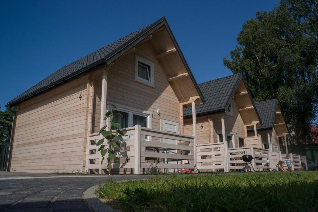 a large wooden house with a gambrel at Te Domki in Łukęcin