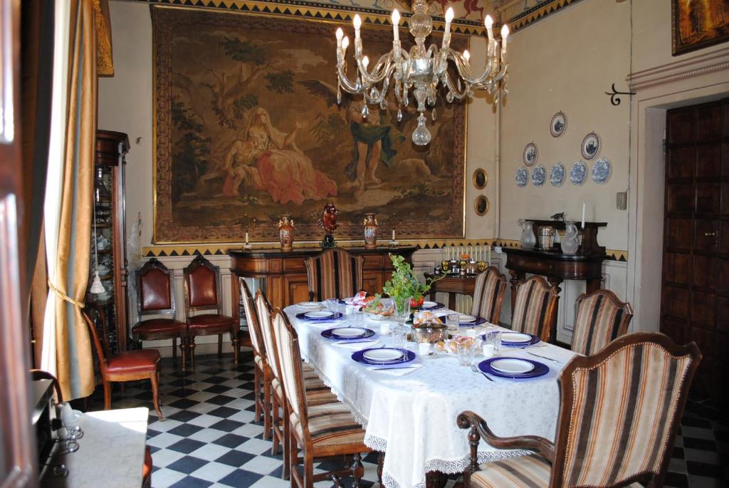 een eetkamer met een tafel en stoelen en een schilderij bij B&B Castello Machiavelli in Ozzano dell Emilia