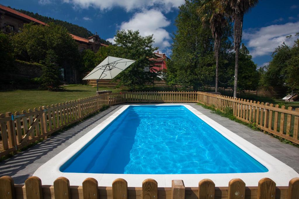 a swimming pool in a backyard with a wooden fence at Posada Seis Leguas in Ríocorvo