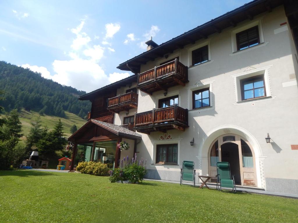 a large building with wooden balconies and a yard at Appartamenti Bait da Erich in Livigno