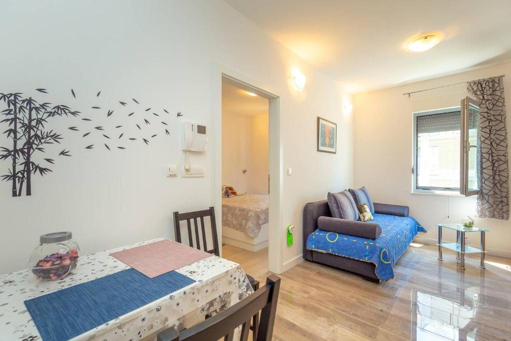 uma sala de estar com um sofá e uma mesa num quarto em Charming Cozy Apartment Solitudo em Dubrovnik