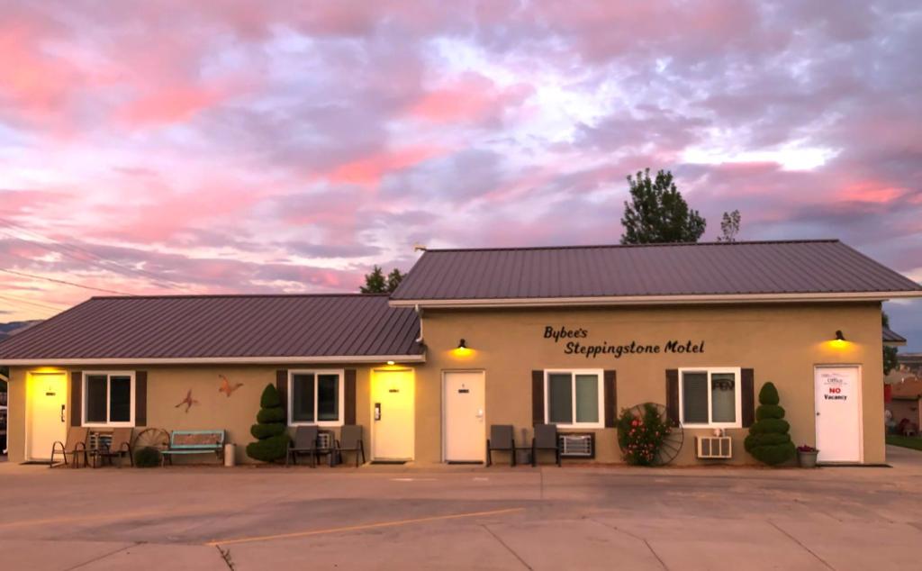 a building with a cloudy sky in the background at Bybee's Steppingstone Motel in Tropic