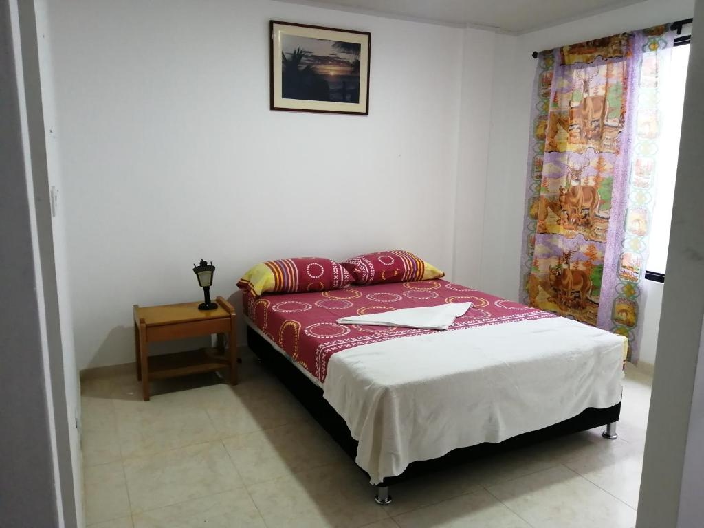 een slaapkamer met een bed met een tafel en een raam bij Hospedaje La Pradera 3 y 7 días -OFF in Jamundí