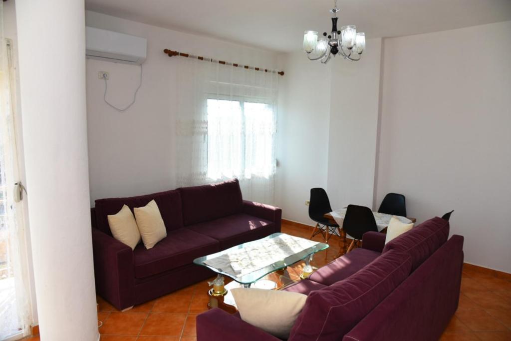 ein Wohnzimmer mit zwei lila Sofas und einem Tisch in der Unterkunft gzim's apartment in Durrës