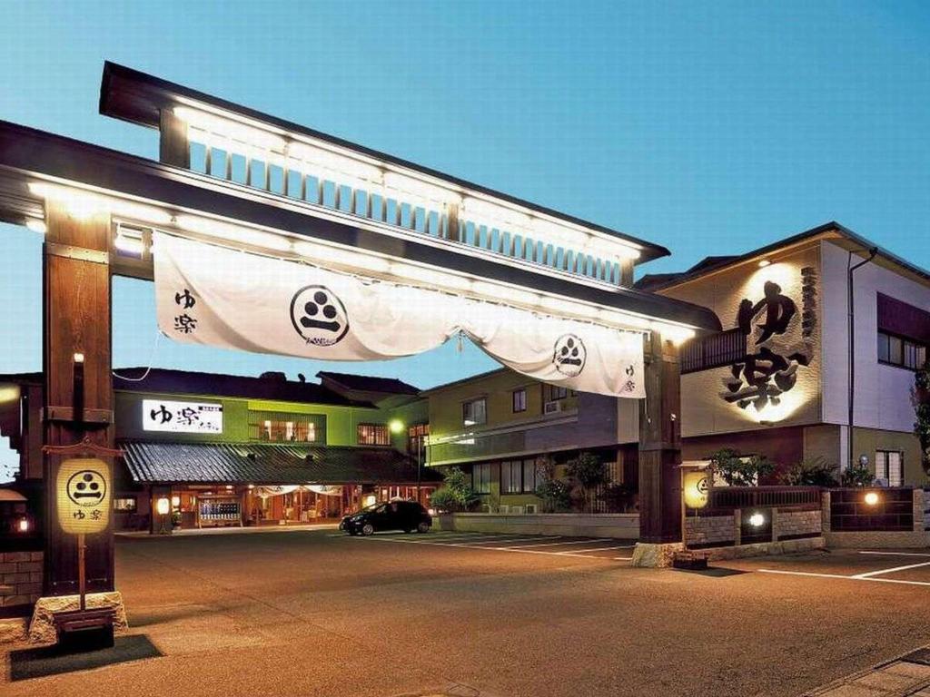 um edifício com um sinal em frente em Yuraku Hotel em Awara