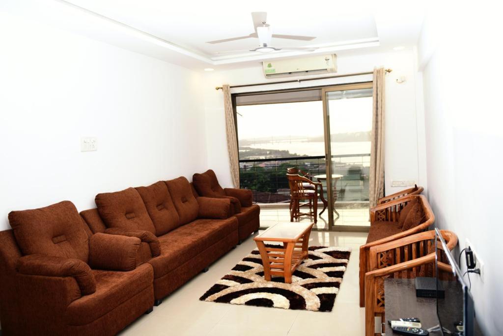 uma sala de estar com um sofá e uma mesa em 3 BHK Apartment with river view em Panaji