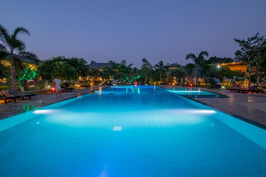 a large swimming pool with blue lighting at night at Sungreen Resort in Habarana
