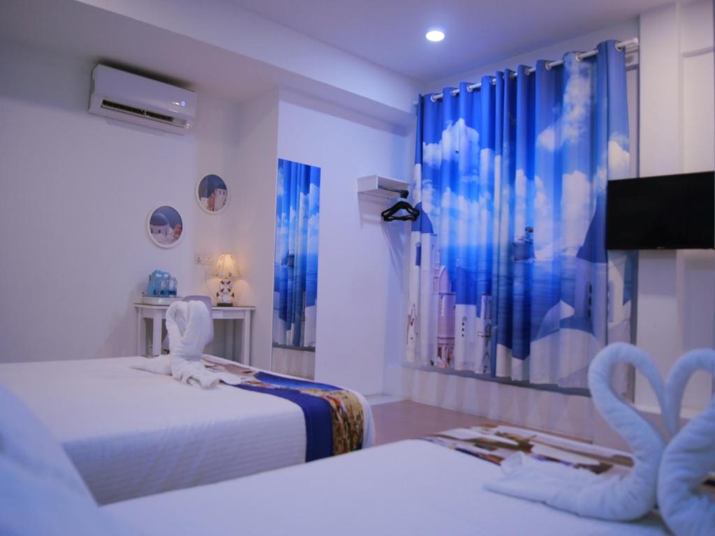 a room with two beds and a tv in it at Santorini Hotel Melaka in Melaka