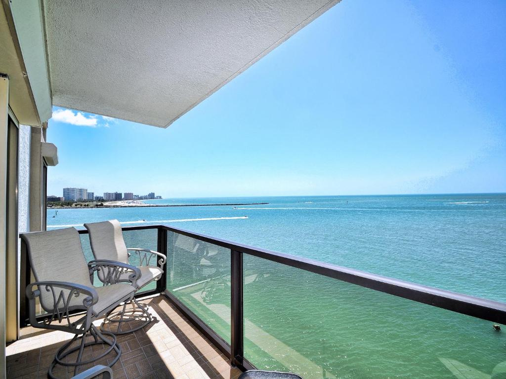 uma varanda com 2 cadeiras e vista para o oceano em 440 West 607N 6th Floor 440 West Condo with Stunning Water View. 23148 em Clearwater Beach