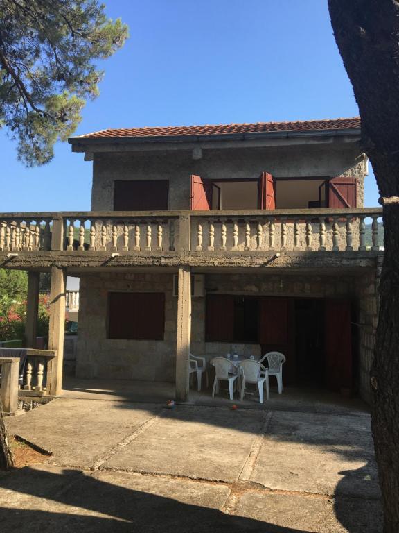 une maison avec une terrasse couverte dotée d'une table et de chaises dans l'établissement Apartman Novica, à Herceg-Novi