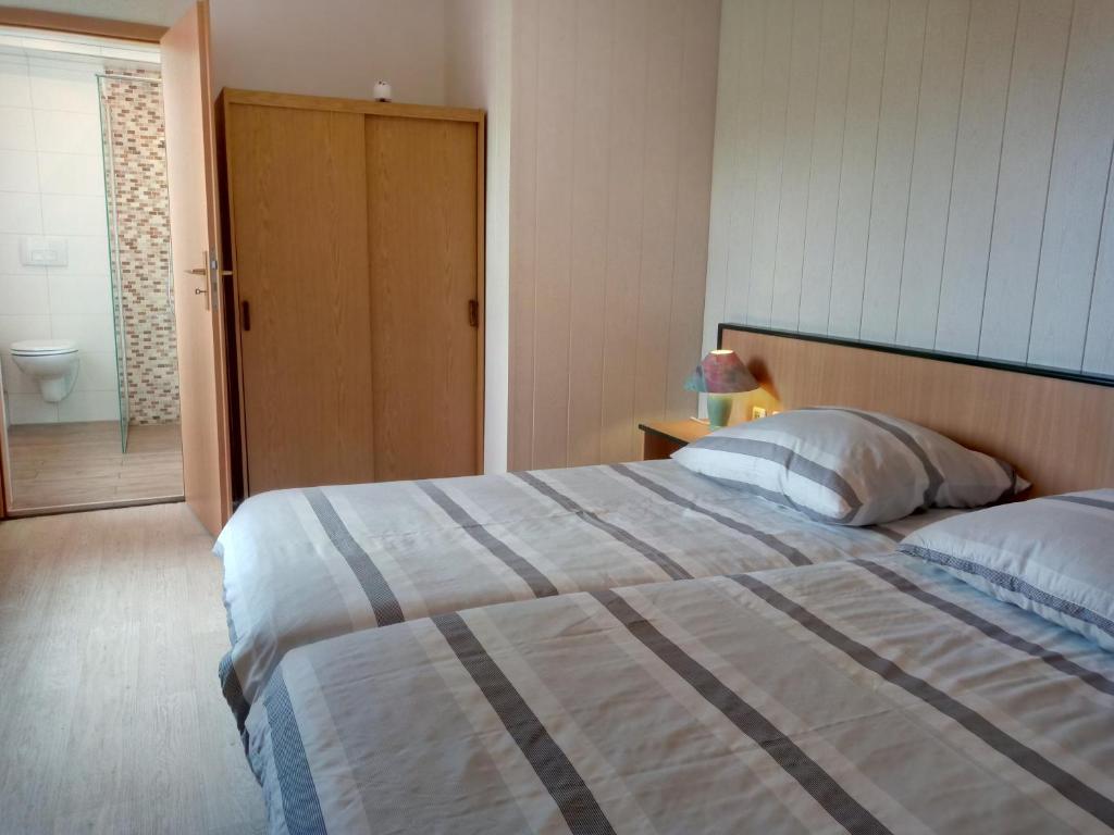 a bedroom with a large bed and a bathroom at Harz meets friends in Hasselfelde