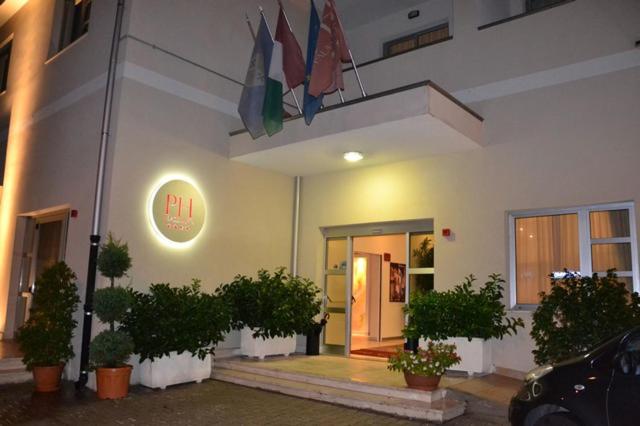 um edifício com uma entrada com plantas em frente em Hotel Palace Gioia Tauro em Gioia Tauro