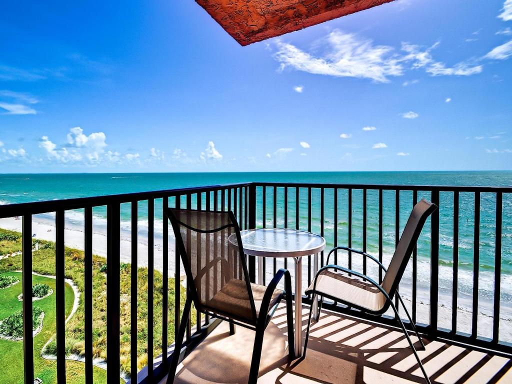 a balcony with two chairs and a table and the ocean at Madeira Towers 601 Beach front with spectacular views 533 in St Pete Beach