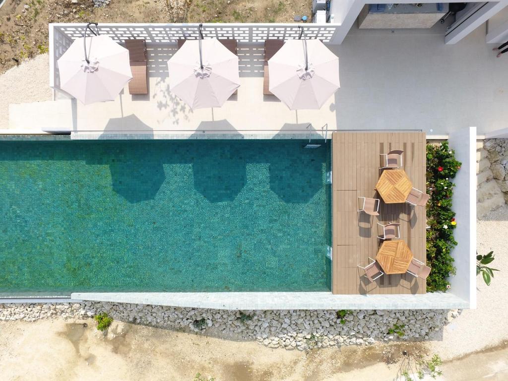 an overhead view of a swimming pool with chairs and umbrellas at The Rescape in Miyako-jima