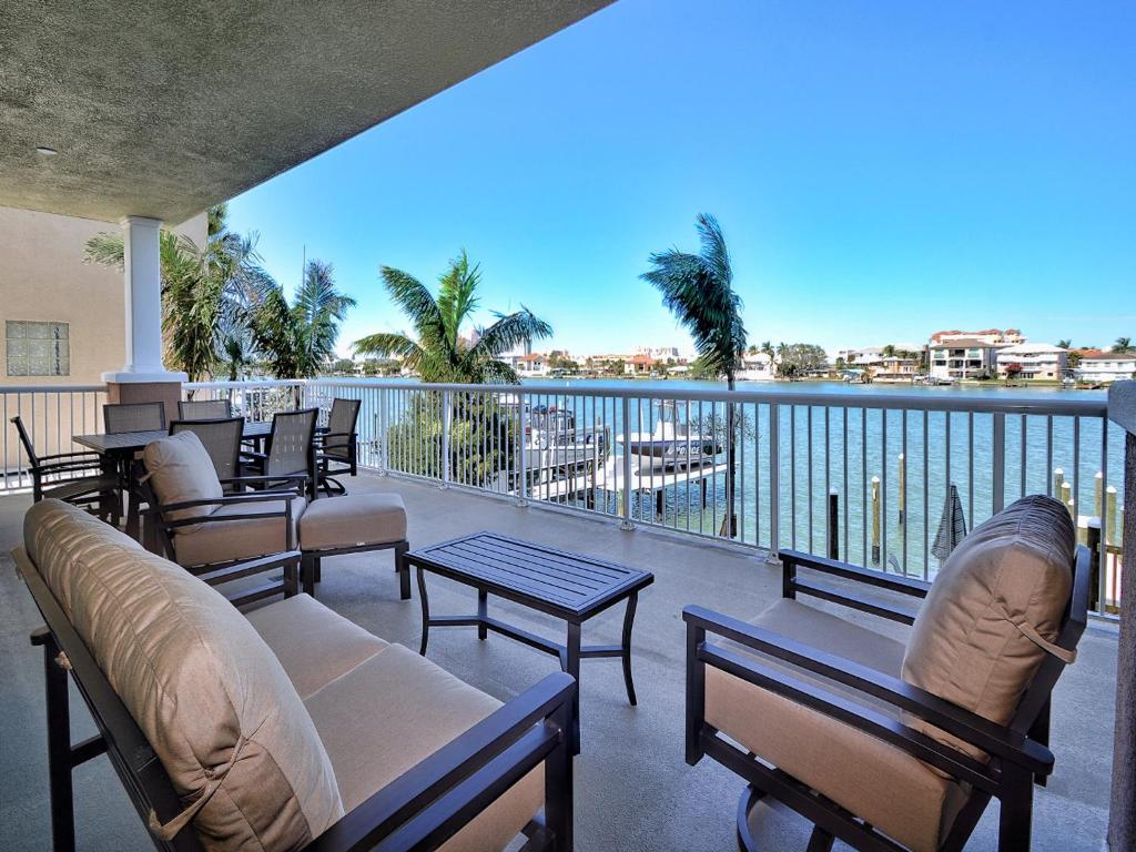 a balcony with chairs and tables and a view of the water at Sandpiper's Cove 201 Sandpiper's Cove Luxury 3 Bedroom 2 Bathroom 23132 in Clearwater Beach