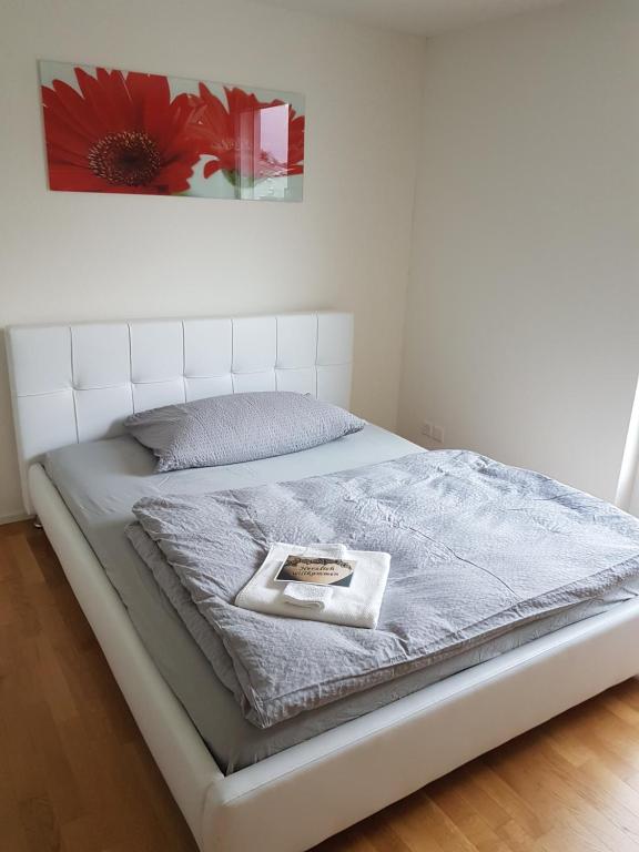 een bed in een slaapkamer met een foto erop bij Zimmer in Penthouse-Wohnung in Windisch