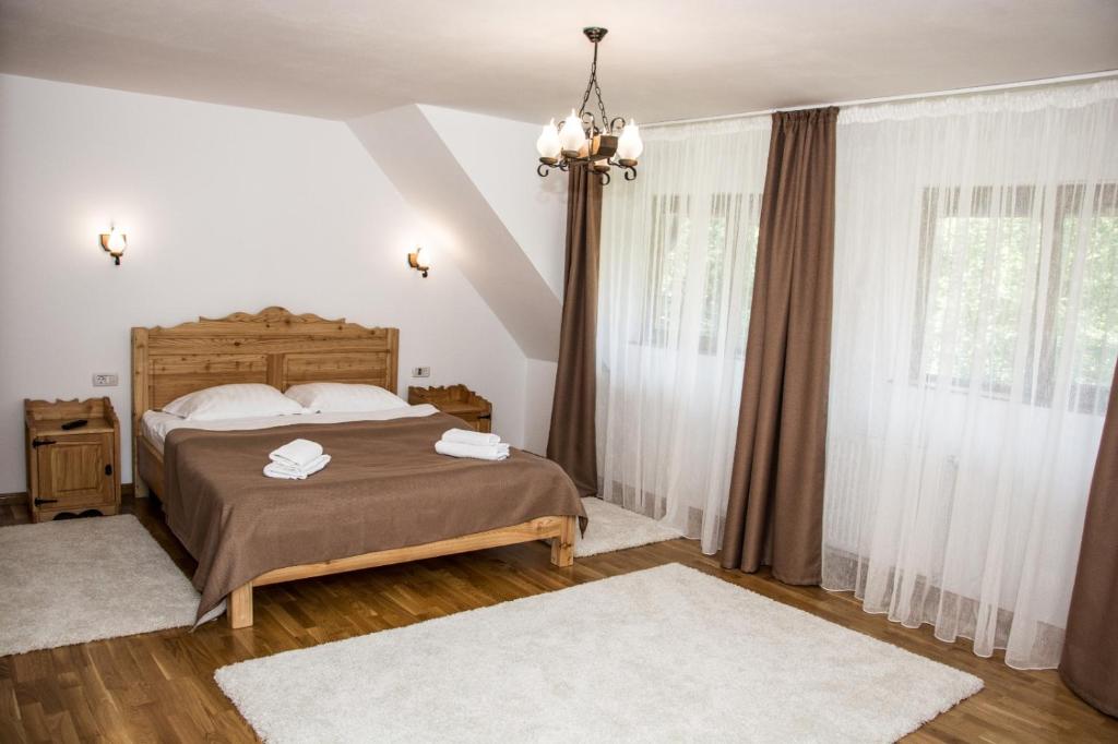 a bedroom with a bed and a large window at Green Forest Bran House in Bran