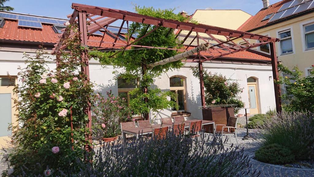 een pergola met een tafel en stoelen in een tuin bij Maison am Liesingbach in Wenen