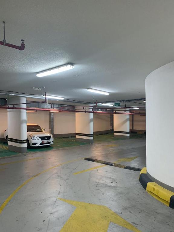 an empty parking garage with a car parked in it at Paragon Hotel Apartments in Abu Dhabi