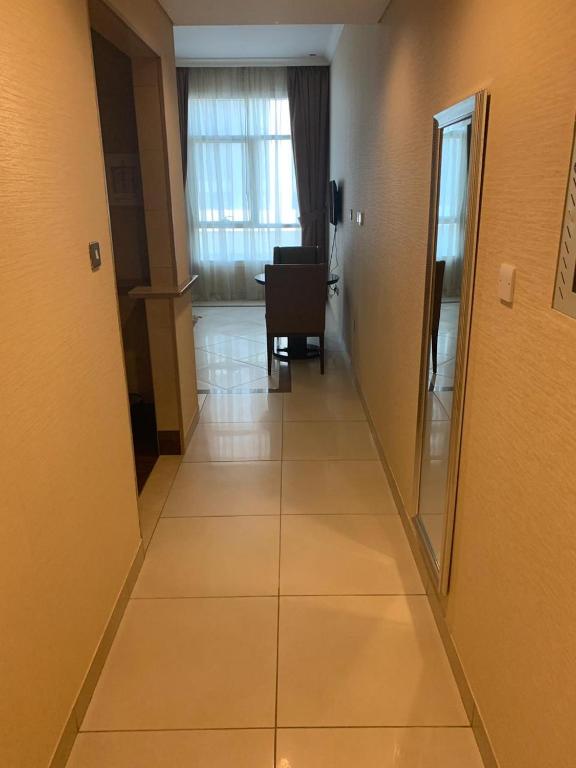 a hallway leading to a room with a table at Paragon Hotel Apartments in Abu Dhabi