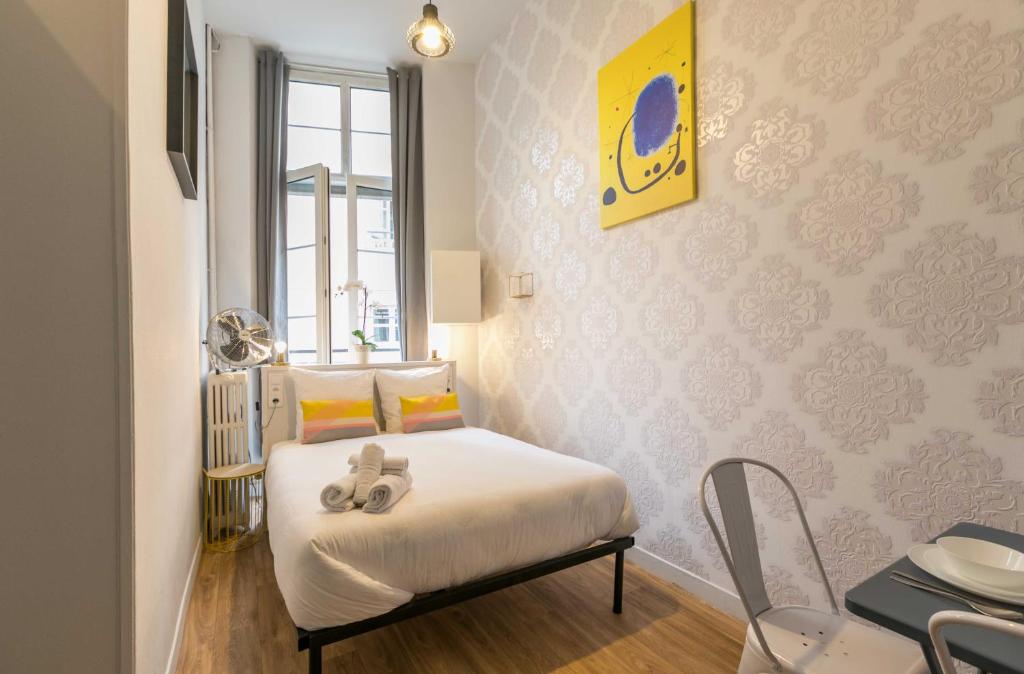 une chambre avec un lit avec deux chaussures dessus dans l'établissement WS Opéra - Vendôme, à Paris