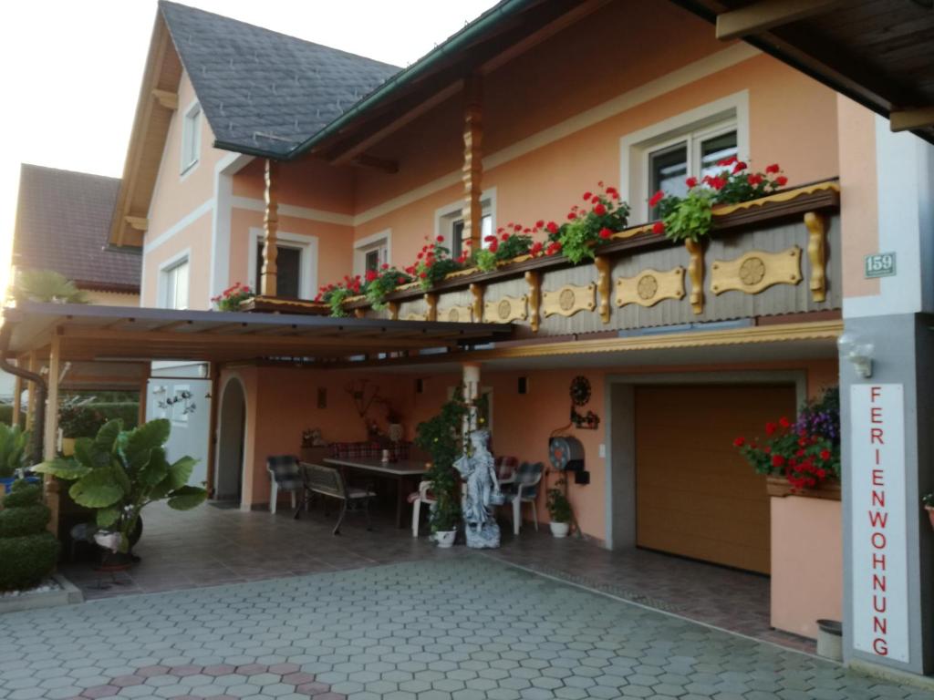 a house with a balcony with flowers on it at Ferienwohnung und Gästezimmer Gaspar in Halbenrain