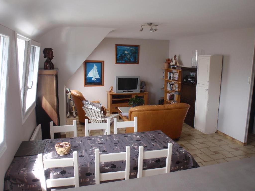 a living room with a table and chairs at 20 Résidence de Kerlosquen in Fouesnant