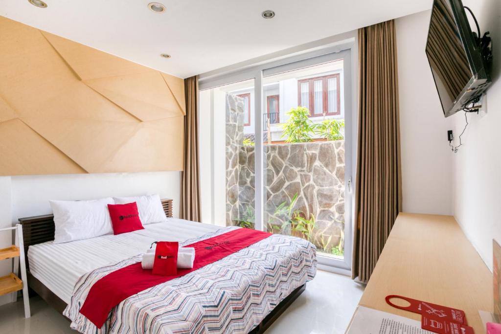 a bedroom with a bed and a large window at RedDoorz near Universitas Islam Indonesia in Yogyakarta