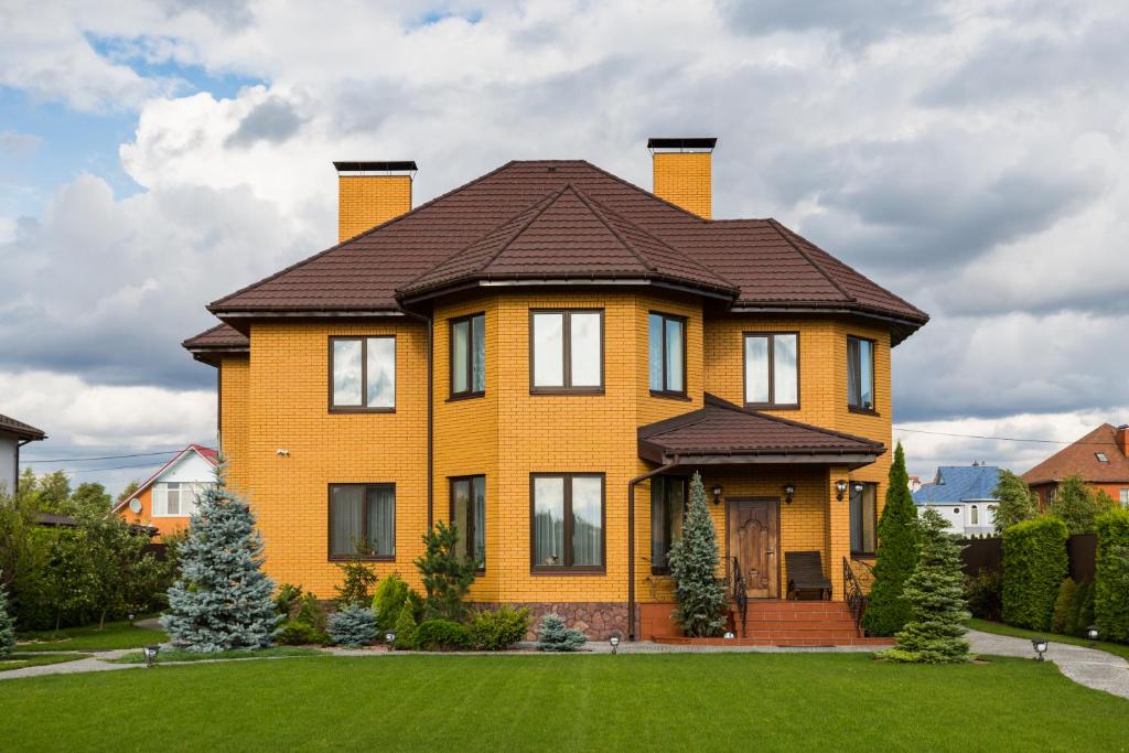 a yellow house with a brown roof at Villa Miliy Dom in Myla