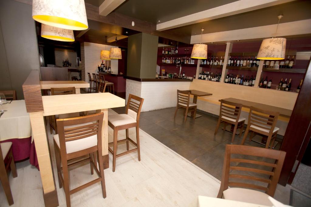 restauracja ze stołami i krzesłami oraz bar w obiekcie Natura Petit Hotel w mieście Revolta