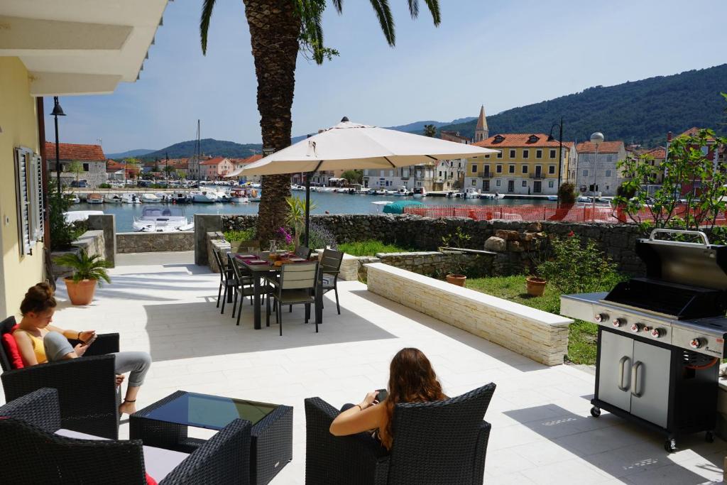 dwoje osób siedzących w fotelach na patio z widokiem na wodę w obiekcie Pascal Villa 7 nights 1 free w mieście Stari Grad