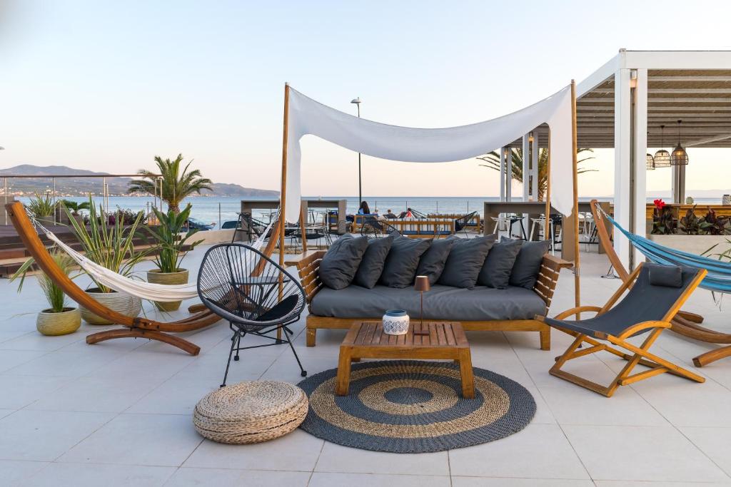 a patio with chairs and a couch and a table at Horizon Blu Boutique Hotel in Kalamata