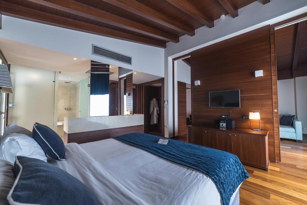 a bedroom with a large bed and a television at Horizon Blu Boutique Hotel in Kalamata