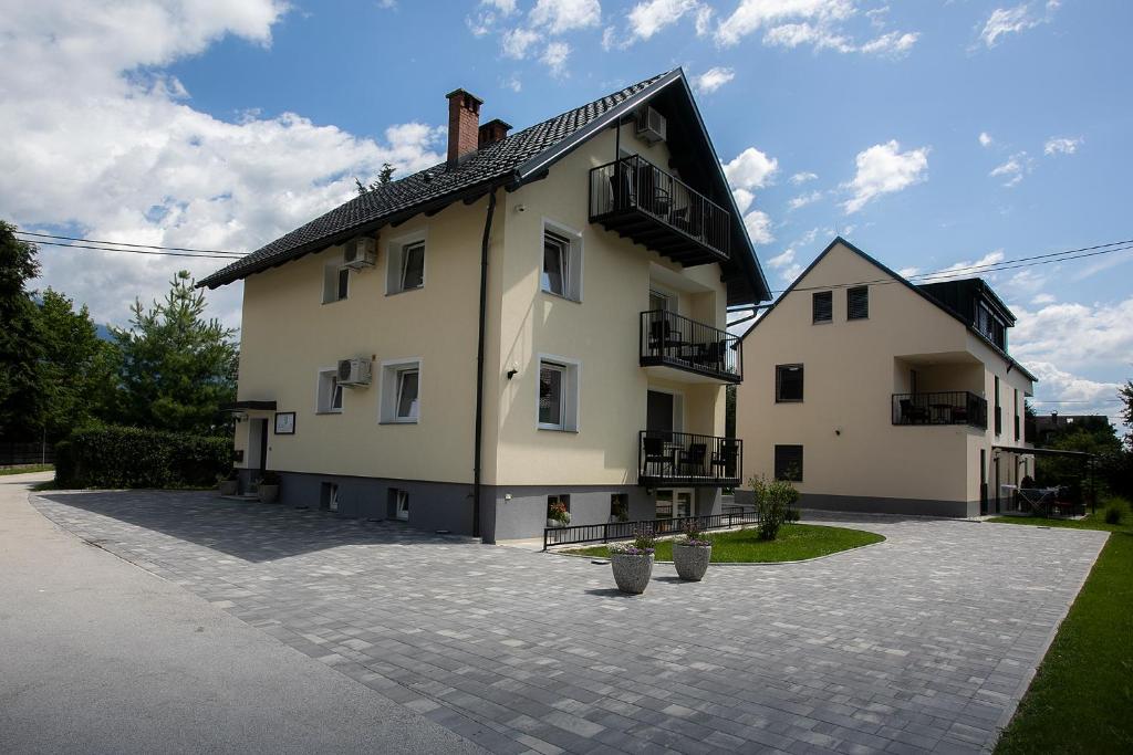 a large white house with a courtyard in front of it at Apartments Razingar 9 in Bled