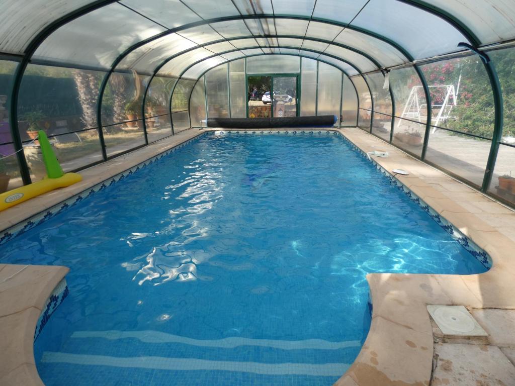 a swimming pool in a greenhouse with a large swimming pool at Lotus in Cébazan