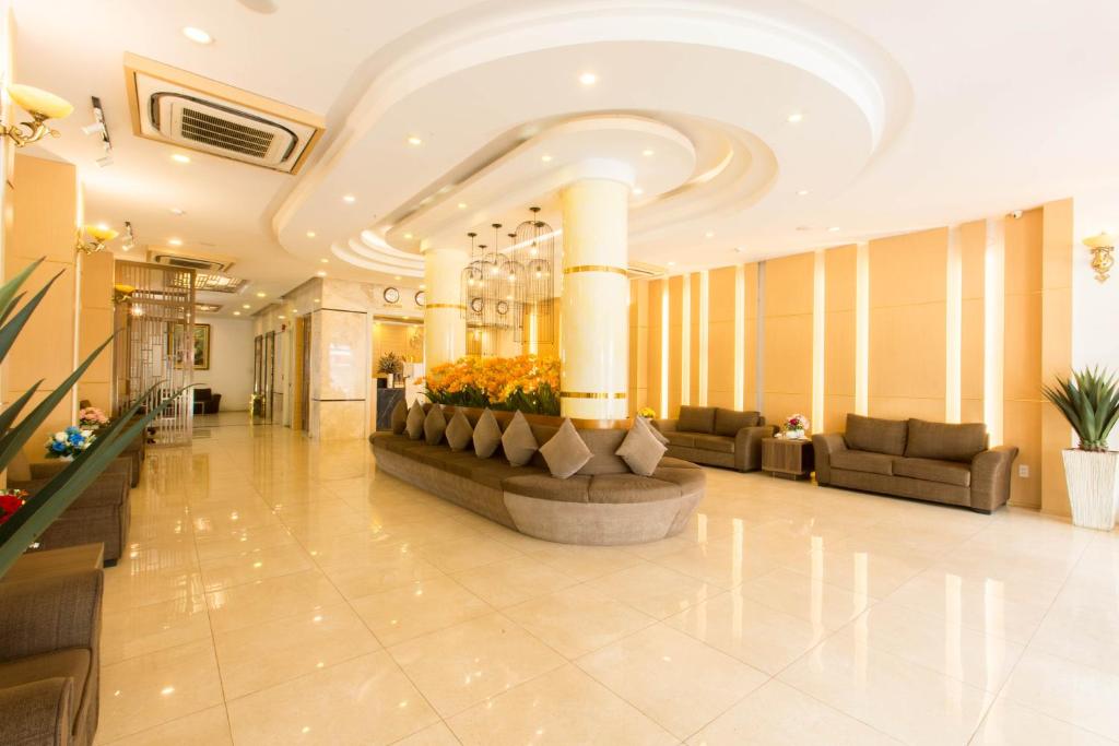 胡志明市的住宿－明譚Spa酒店，大厅,带有长沙发和鲜花的酒店