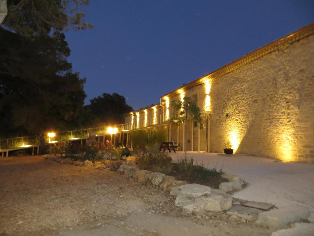 Junas的住宿－Domaine de Christin Studios-Hôtel，一座砖砌的建筑,晚上有灯