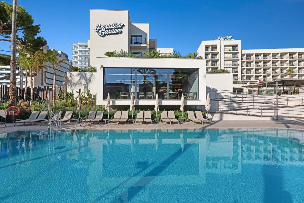 a swimming pool with chairs in front of a hotel at Hotel Paradiso Garden in Playa de Palma