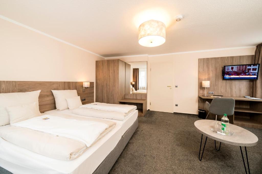 Postel nebo postele na pokoji v ubytování Parkhotel Lingen by Hackmann