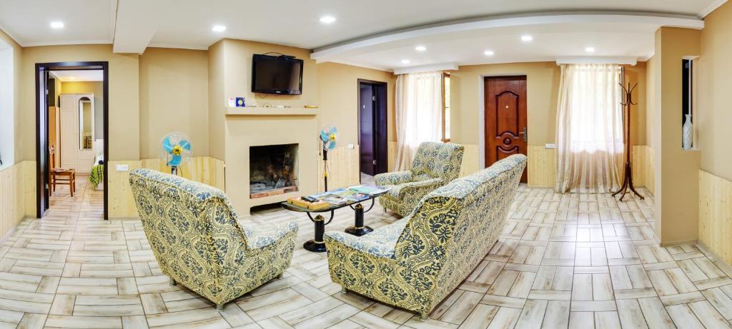 ein Wohnzimmer mit Stühlen und einem Kamin in der Unterkunft Guest House Mart Villa in Martvili