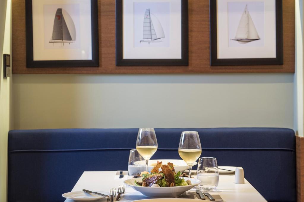 a table with a plate of food and wine glasses at Horizon Blu Boutique Hotel in Kalamata