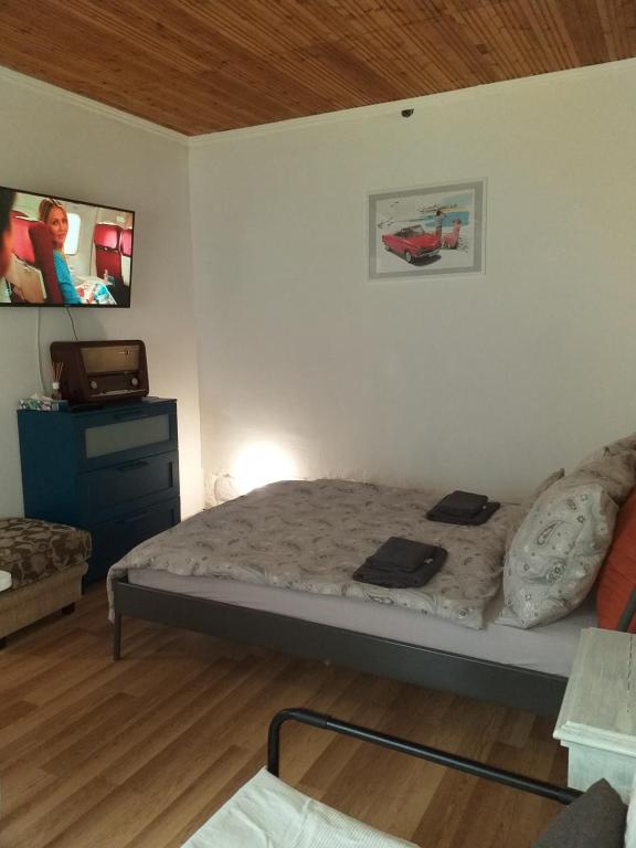 um pequeno quarto com uma cama e uma televisão em Ov152 Apartman em Budapeste