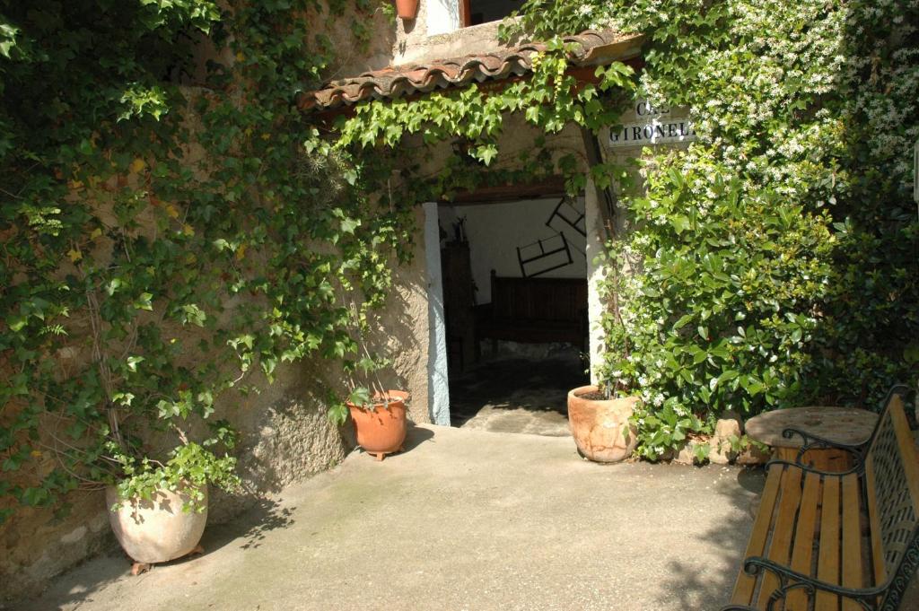 une arche avec un banc et quelques plantes dans l'établissement Cal Gironell, à Santa María de Meyá