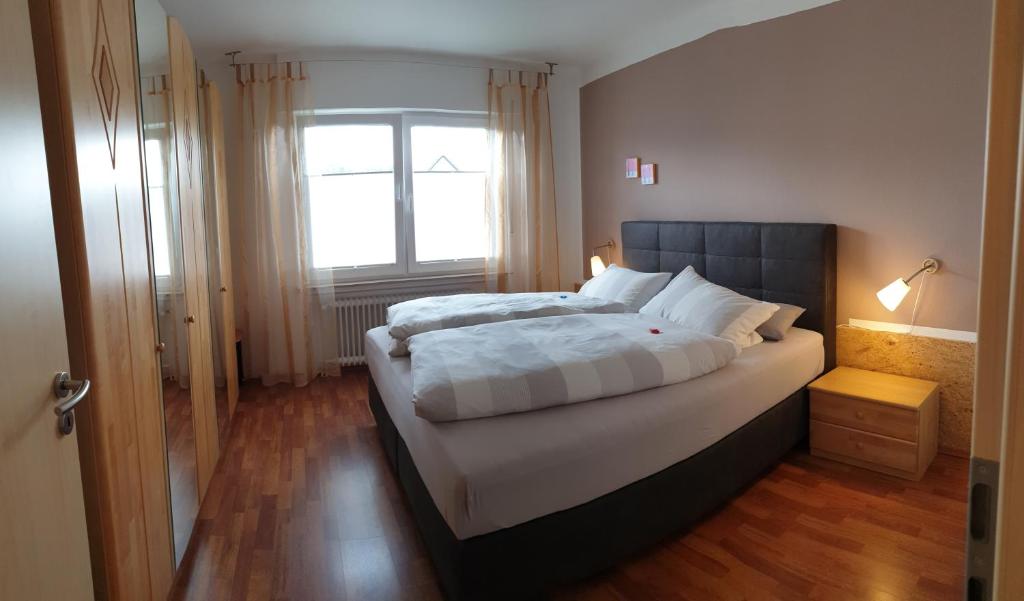 een slaapkamer met een groot bed en een raam bij Haus Bramland --- 2 FeWo's --- EG 60qm und OG 55qm in Haselünne