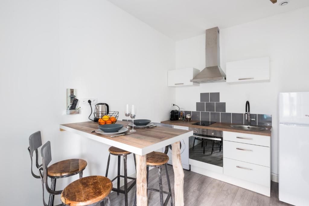 eine Küche mit einem Holztisch und Stühlen in der Unterkunft Appartement Cosy 4P - L'Ar Zenith in Saint-Malo