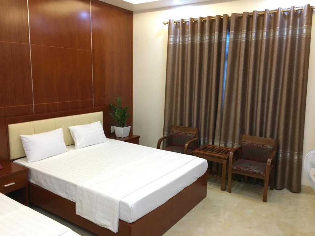 Bình Minh Riverside Hotel في Thái Bình: غرفه فندقيه بسرير وكرسيين
