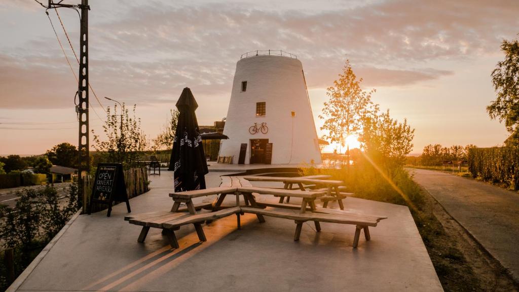 a group of picnic tables in front of a lighthouse at Hotond Sporthotel in Kluisbergen